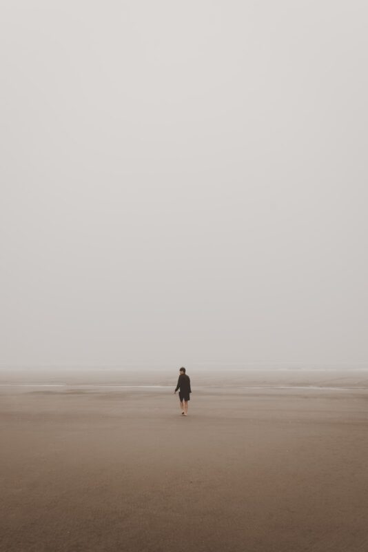 man standing on brown sand