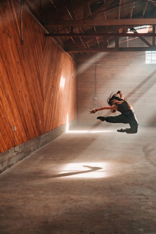 Photo by Daniel man in black jacket and black pants jumping on brown wooden floor