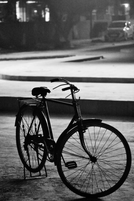 grayscale photography of bike parking near road