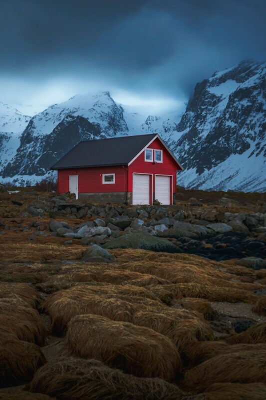 a red house with a mountain in the background