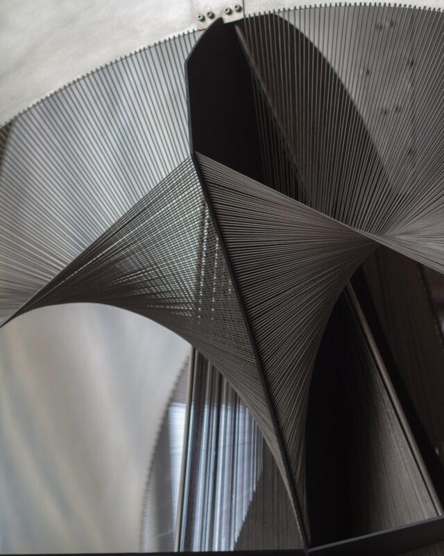 a close up of a metal structure with a clock in the background