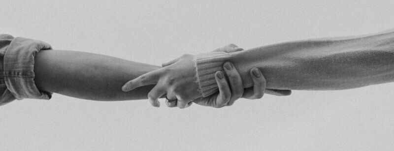 grayscale photo of person holding hands